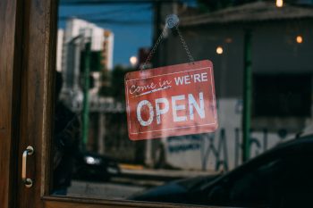 Traditional welcoming “We’re Open” sign in shop window