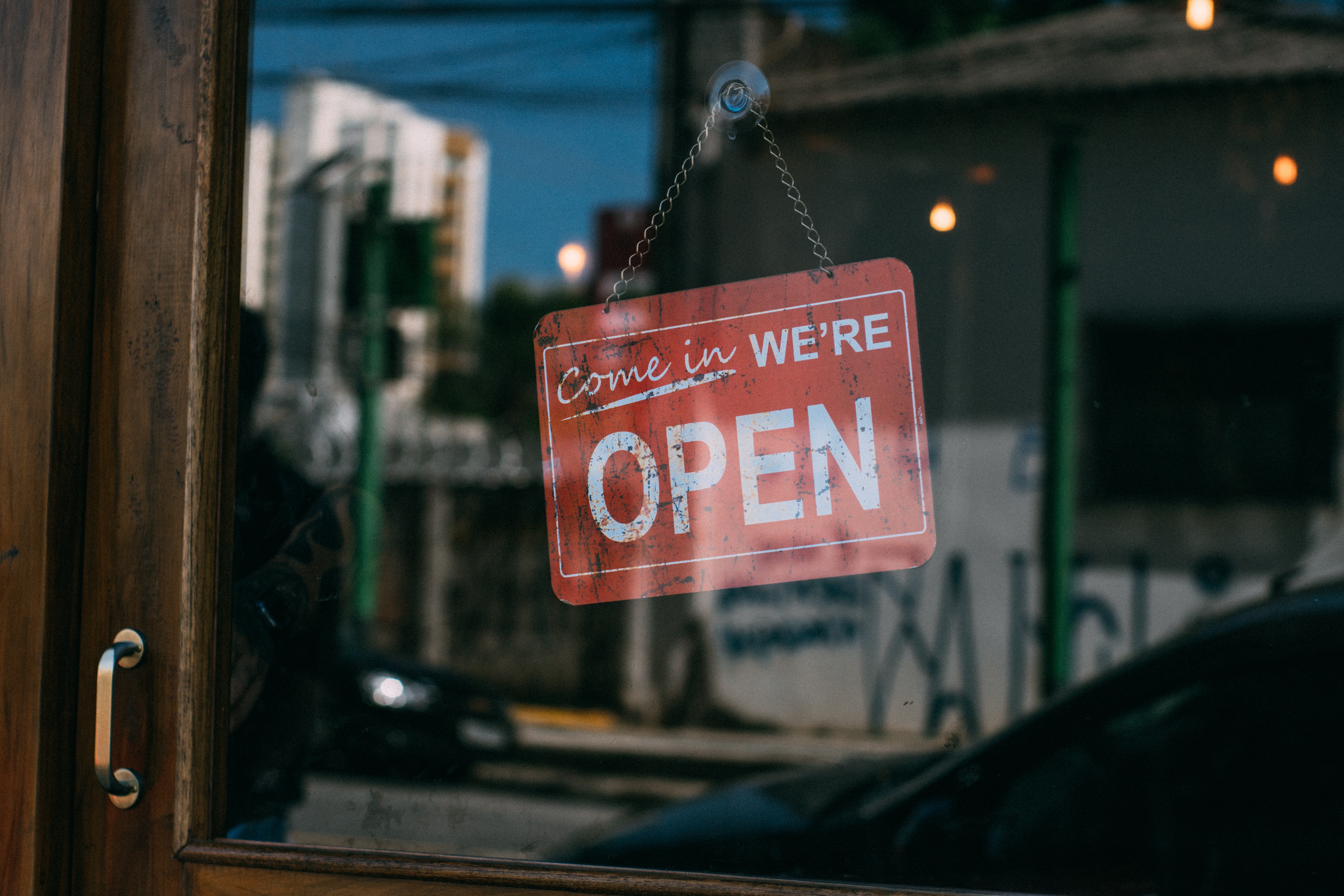 Traditional welcoming “We’re Open” sign in shop window