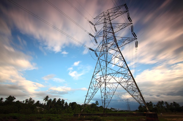 An electricity transmission tower rising high into the countryside