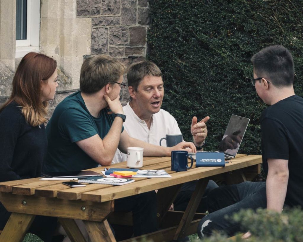 Interns discussing work with Epimorphics team leaders over coffee